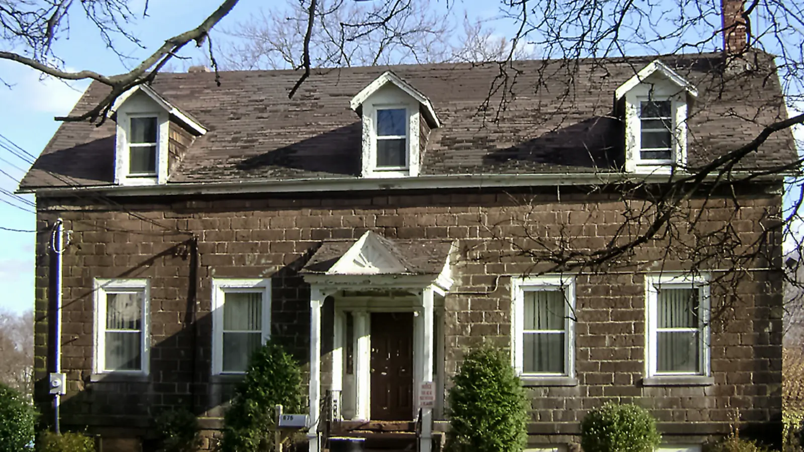 Attached brick rowhouse facade along an urban residential block.